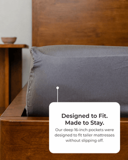 Gray pillow on a wooden bed with text about mattress design.