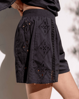 Black embroidered skirt worn by a person against a neutral background