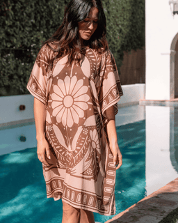 Woman wearing a patterned dress by a poolside