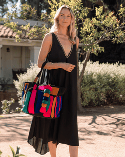 Woman holding a colorful handbag outdoors