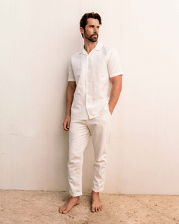 Man wearing a white outfit against a plain background