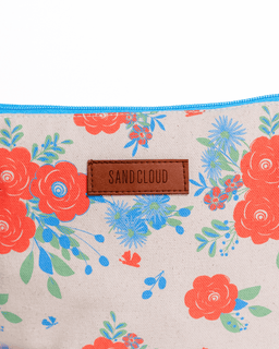 Floral-patterned pouch with 'Sandcloud' branding on a beige background