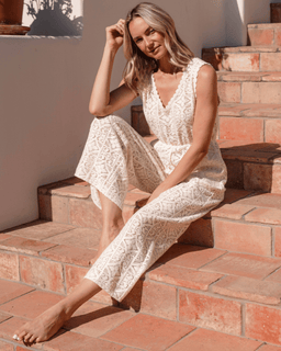 Woman in a white lace dress sitting on stone steps outdoors