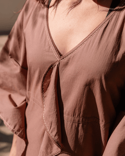 Close-up of a brown blouse with a V-neckline