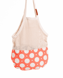 Mesh shopping bag with a coral base featuring white polka dots on a white background
