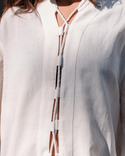Close-up of a white cover up with a zipper and drawstrings.