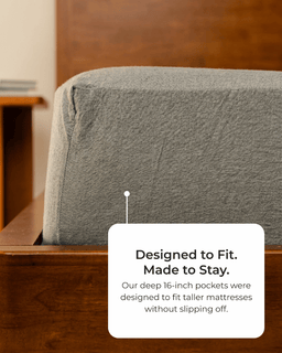Gray mattress cover on a wooden bed frame with text about mattress size compatibility.