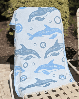 Towel with dolphin pattern draped over a chair outdoors