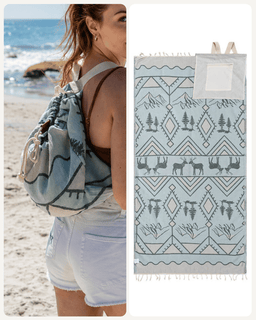 A beach-themed drawstring backpack shown worn by a woman on a sandy beach, alongside a flat product view of the matching patterned towel. The product features a light blue and white geometric design with mountain, tree, and deer motifs, and a white pocket on the front.