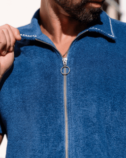 Close-up of a person wearing a blue fleece jacket with a zipper.