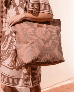 Person holding a patterned bag with a neutral background
