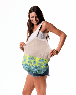 Woman holding a beige tote bag with floral design on a white background