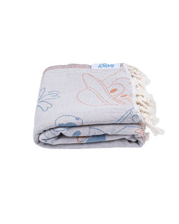 Folded towel with floral patterns and tassels on a white background