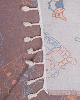Textile with embroidered patterns and tassels on a brown and gray background