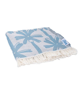 Blue palm tree patterned towel with white fringe on a white background