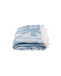 Folded blue and white patterned towel with white fringe on a white background