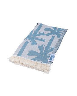 Blue palm tree patterned towel with white fringe on a white background