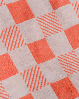 Patterned fabric with orange squares and diagonal lines on a beige background