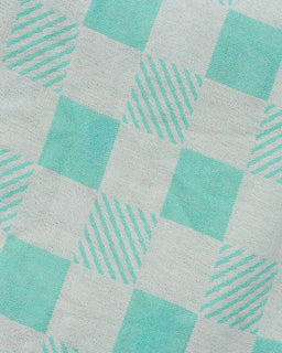 Patterned fabric with turquoise squares and lines on a light gray background
