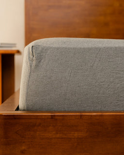 moss fitted sheet on a wooden bed frame