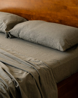 moss bedding set on a bed with a wooden headboard