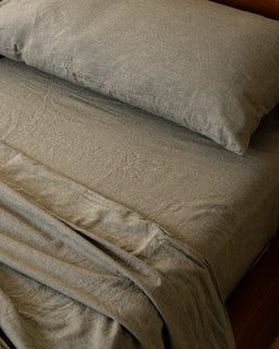 Close-up of a moss sheets and pillow on a bed.