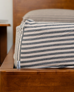 Striped pillow on a wooden bed frame