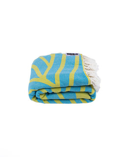 Folded blue and green patterned towel with a brand label on a white background