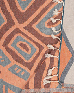 Close-up of a patterned towel with geometric design in brown, blue, and orange colors.