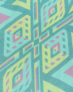 A close-up of a geometric patterned fabric featuring a repeating diamond and cross motif in teal, lime green, pink, and yellow.