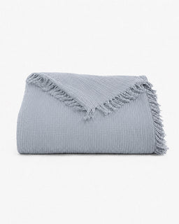 A folded light gray textured throw blanket with fringed edges, displayed on a clean white background.