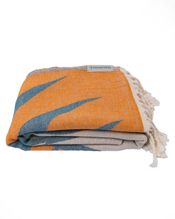 Folded towel with orange, blue, and beige pattern on a white background
