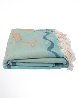 Folded teal towel with white fringe on a white background