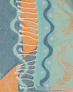 Textile with wavy patterns and orange accents on a blue and green background