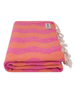 Folded pink and orange striped towel with tassels on a white background