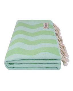 Folded green and white striped towel with tassels on a white background