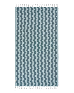 Blue and white wavy patterned towel with fringes on a white background