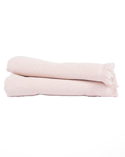 A folded light pink hand towels with fringed edges, shown on a plain white background.