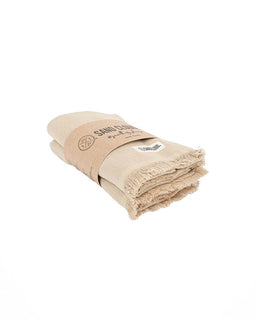 A folded beige fringed hand towels wrapped in a brown paper band 