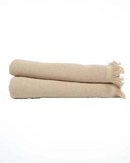 Two folded beige woven hand towels with fringed edges, stacked horizontally on a clean white background.