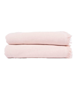 Two folded light pink woven bath towels with fringed edges stacked vertically on a plain white background.