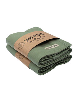 Folded green towel with a brown paper wrap displaying 'Sand Cloud' branding on a white background.