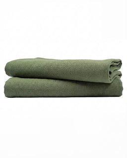 Folded green towel on a white background