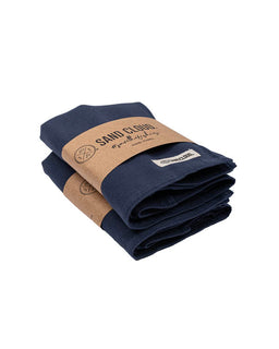 Folded navy blue fabric with a brown paper label on a white background
