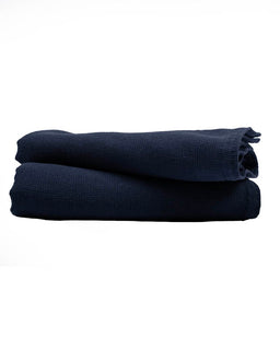 Two folded navy blue hand towels on a white background