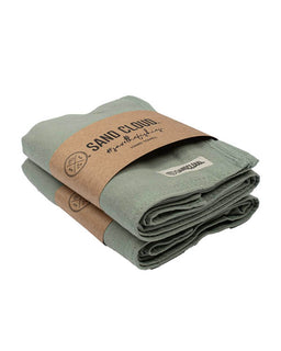 Folded green towel with a brown paper label on a white background