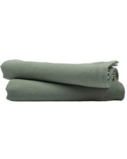 Folded green towel on a white background