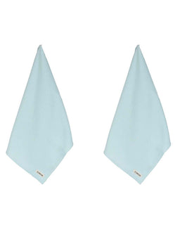 Two light blue triangular towels with gold labels on a white background