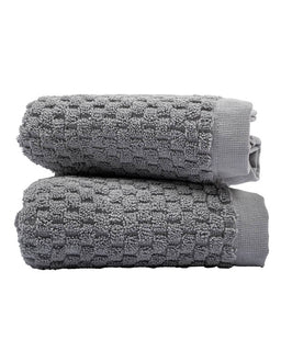 Two gray textured towels stacked on a white background
