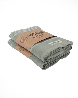 Folded green towel with a brown paper bag on a white background